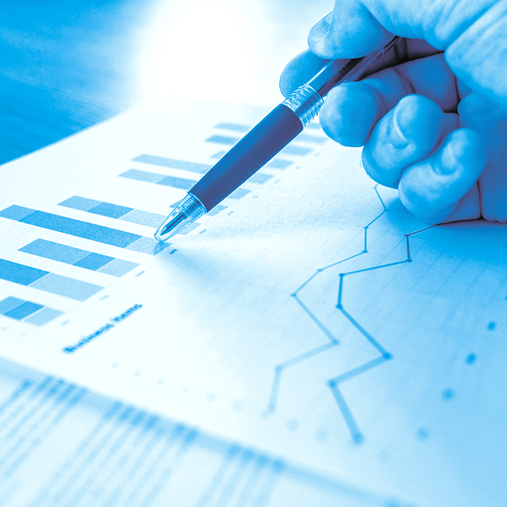 hand holding a pen looking over graphs on paper hand holding a pen looking over graphs on paper
